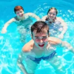 Familia feliz en piscina azul y limpia