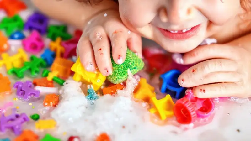 Un niño limpia juguetes coloridos y divertidos